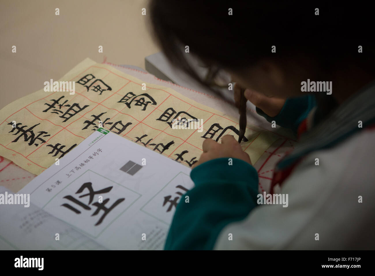 (151123) -- BEIJING, Nov. 23, 2015 (Xinhua) -- A pupil in Jingyuan primary school practises calligraphy in Beijing, capital of China, Nov. 23, 2015. Calligraphers came to Jingyuan primary school to give guidance on calligraphy on Monday.  (Xinhua/Guo Yu) (dhf) Stock Photo