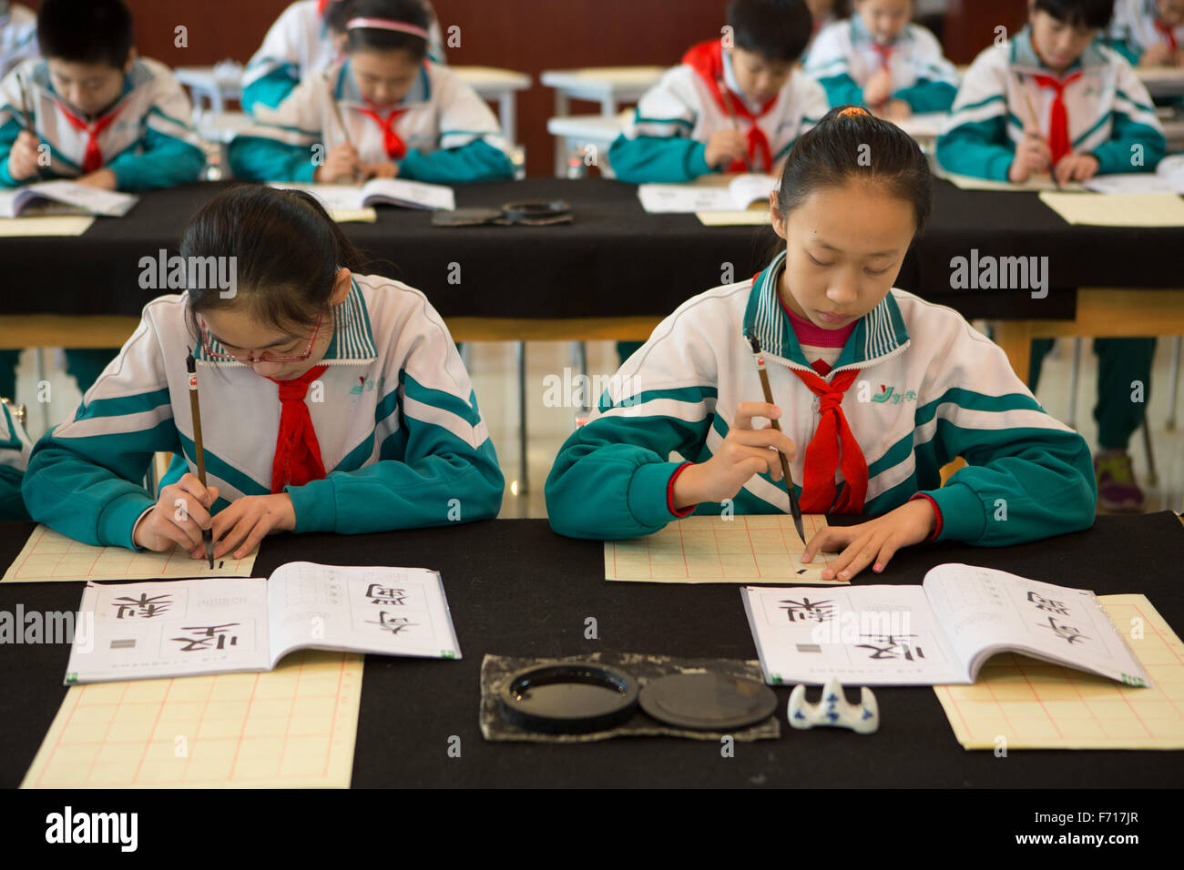(151123) -- BEIJING, Nov. 23, 2015 (Xinhua) -- Pupils in Jingyuan primary school practise calligraphy in Beijing, capital of China, Nov. 23, 2015. Calligraphers came to Jingyuan primary school to give guidance on calligraphy on Monday.  (Xinhua/Guo Yu) (dhf) Stock Photo