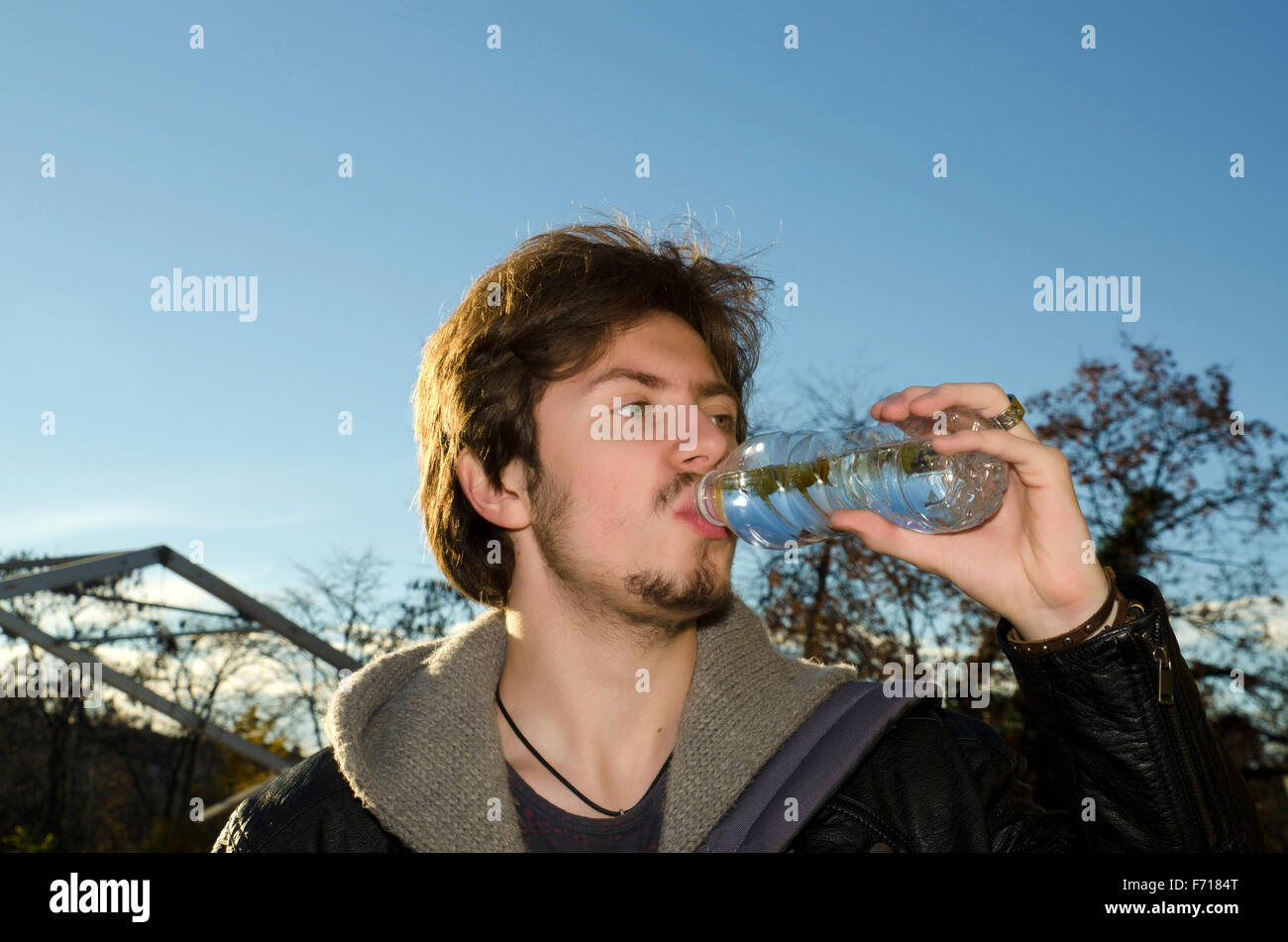 Teenager drinking mineral water in a bottle in a park Stock Photo