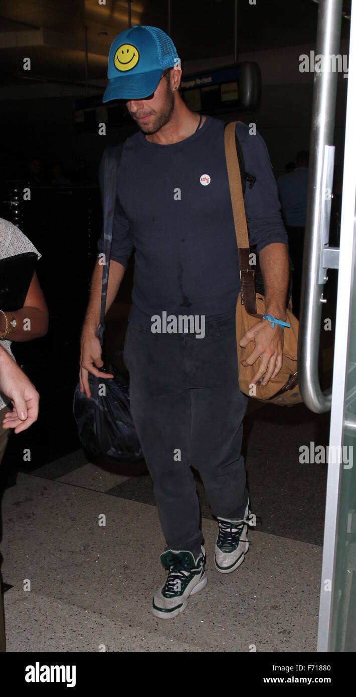 Chris Martin arrives from a flight at Los Angeles International Airport  (LAX) wearing a smiley face baseball cap and a 'Love' badge on his t-shirt  Featuring: Chris Martin Where: Los Angeles ,