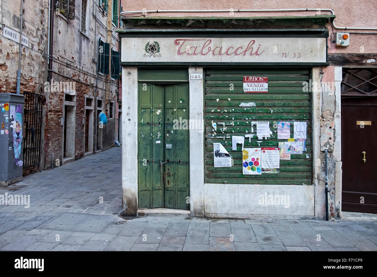 Venice, Castello. Tobacconist Shop for sale, Closed Tabacchi with shuttered display window and old notices Stock Photo