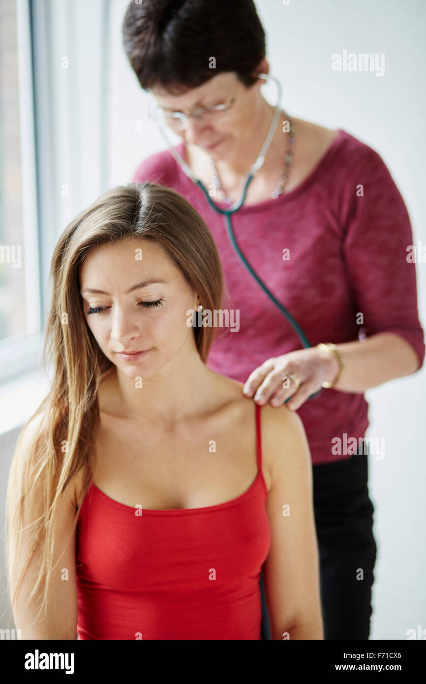 Doctor listening to patients back and chest Stock Photo