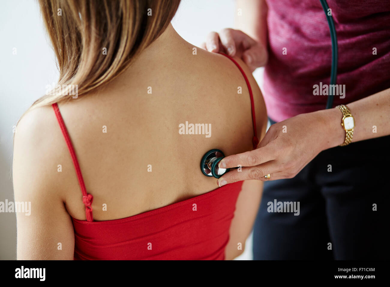 Doctor listening to patients back and chest Stock Photo