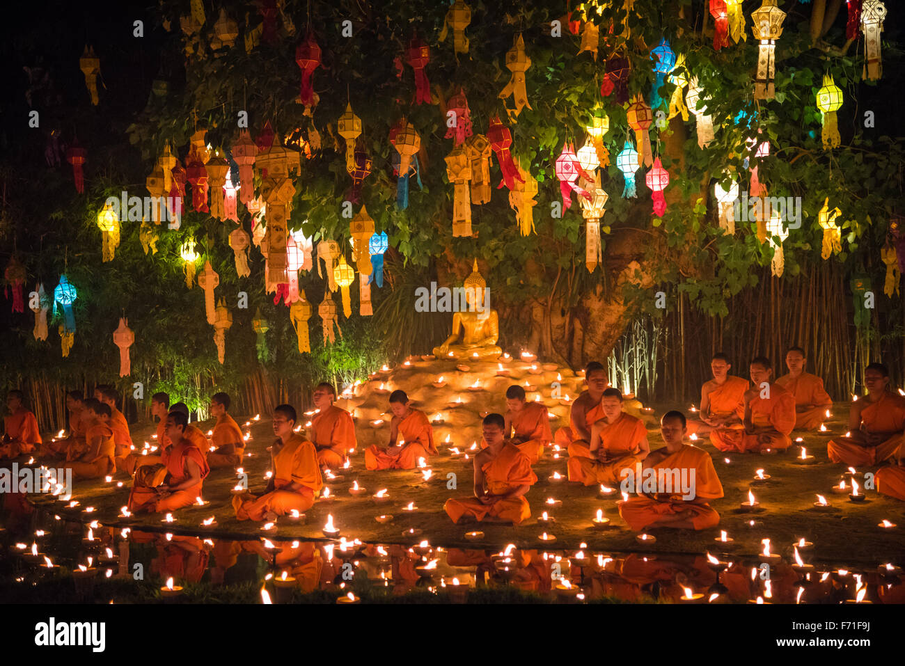 Monks meditation near the pond in Loy Krathong festival at Wat Phan Tao temple. Chiang Mai, Thailand. Stock Photo