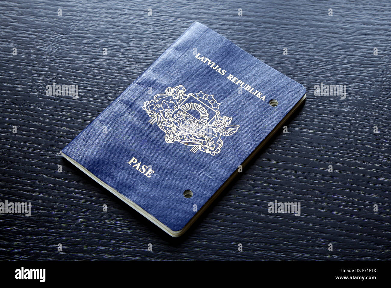 expired invalid passport damaged after expiration day with holes on black table Stock Photo