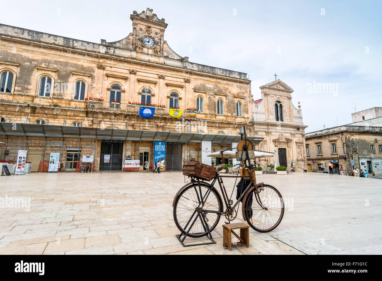 old knife grinder bicycle and main square in Ostuni, Italy Stock Photo