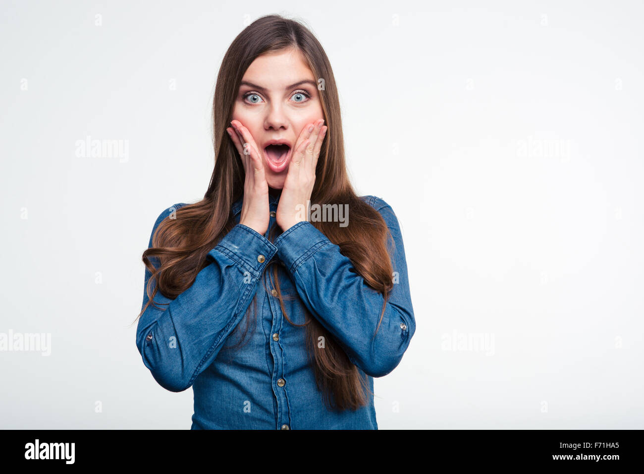 Portrait of a young amazed woman standing isolated on a white ...