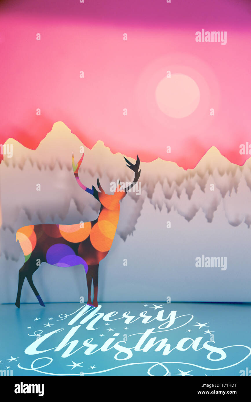 Merry christmas handmade paper cut winter scene in pop art style: deer with bokeh lights and forest landscape on sunset sky back Stock Photo