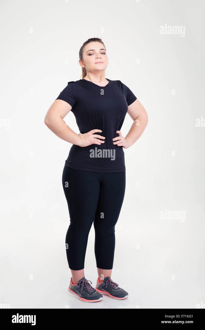 Full length portrait of a fat woman in sports wear standing isolated on a white background Stock Photo