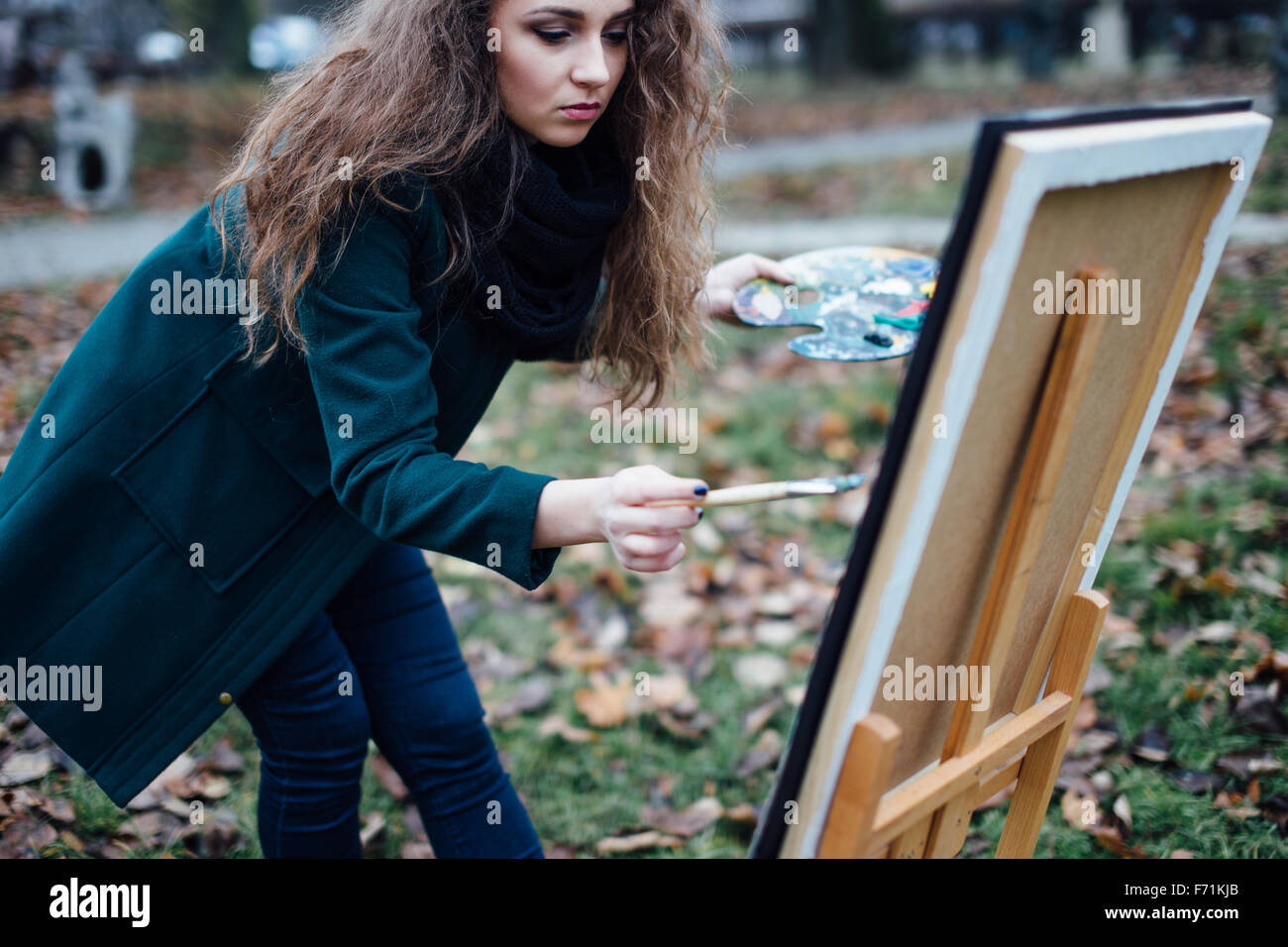 Young woman drawing in easel on the park background Stock Photo - Alamy