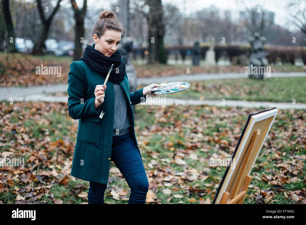 Young woman drawing in easel on the park background Stock Photo - Alamy