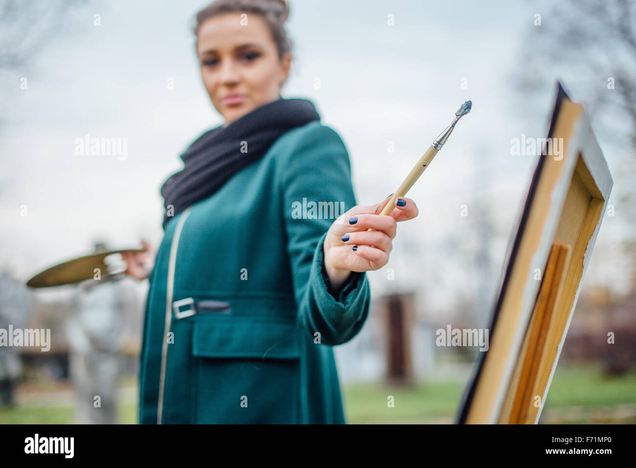 Young woman drawing in easel on the park background Stock Photo - Alamy