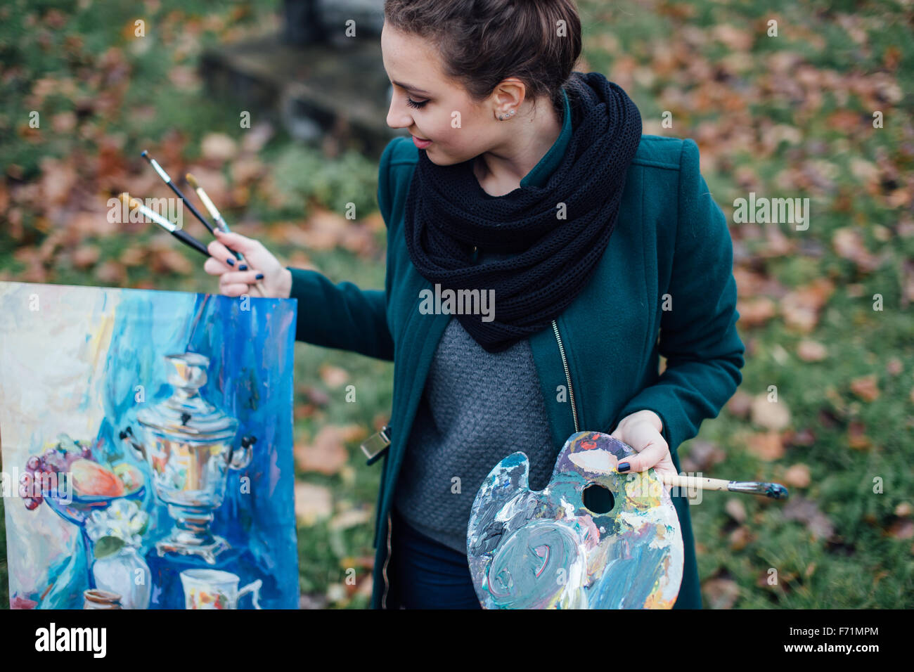 Young woman drawing in easel on the park background Stock Photo - Alamy