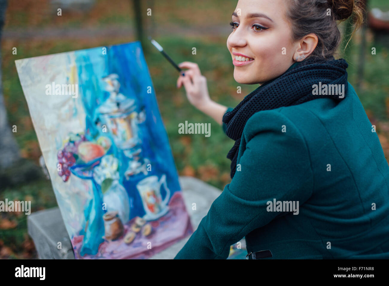 Young woman drawing in easel on the park background Stock Photo - Alamy
