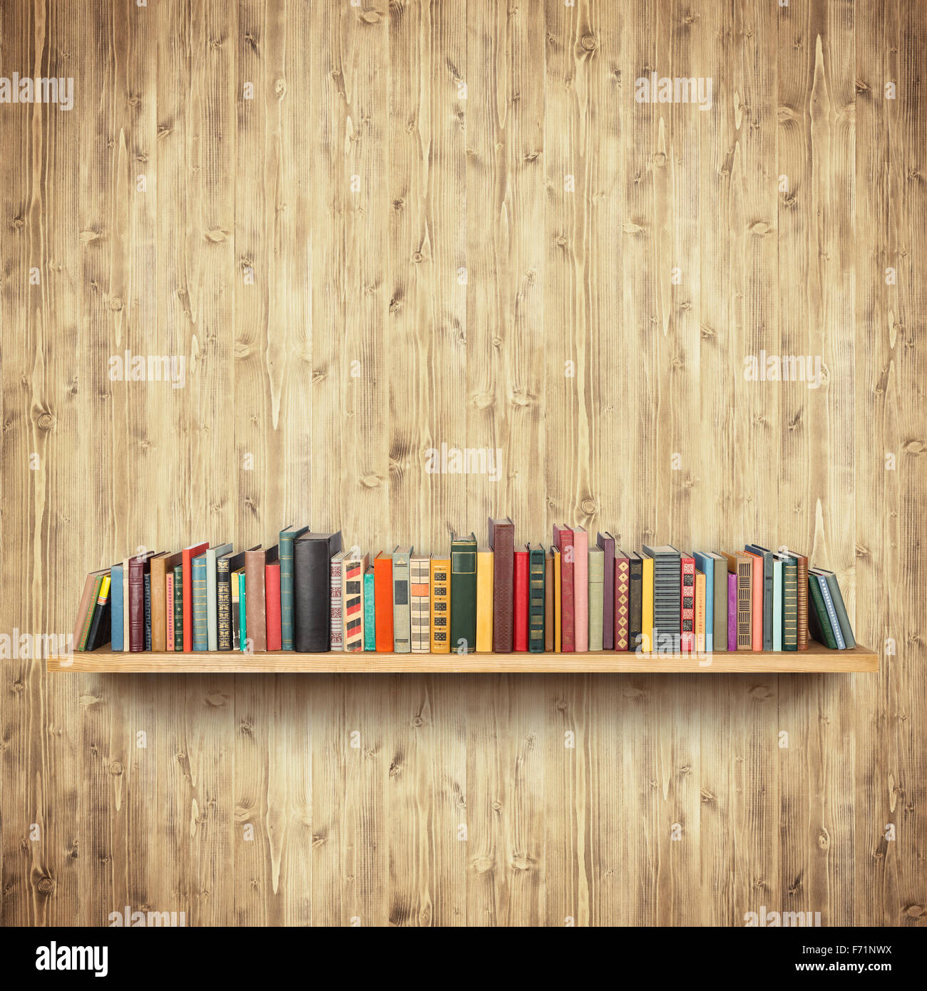 Bookshelf on yellow wooden wall Stock Photo
