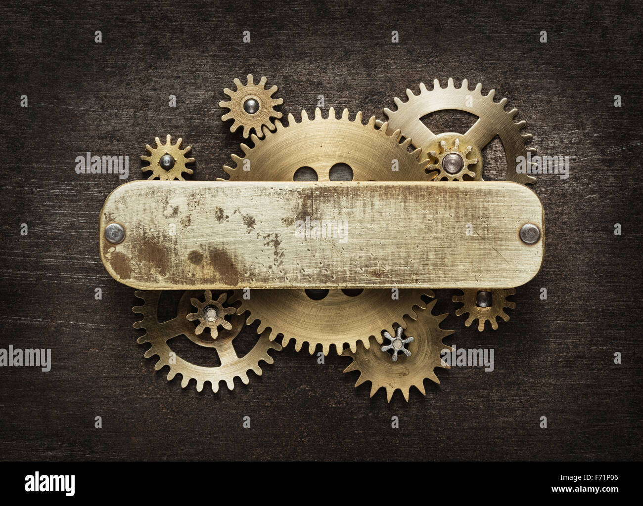 Clockwork mechanism background made of metal gears and brass plate. Stock Photo