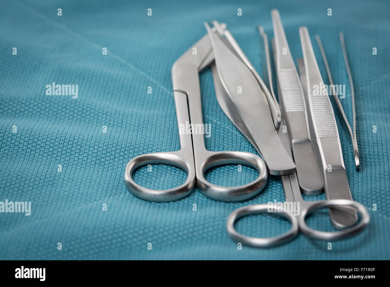 Detail of surgical instruments and tools on a tray covered with green cloth Stock Photo