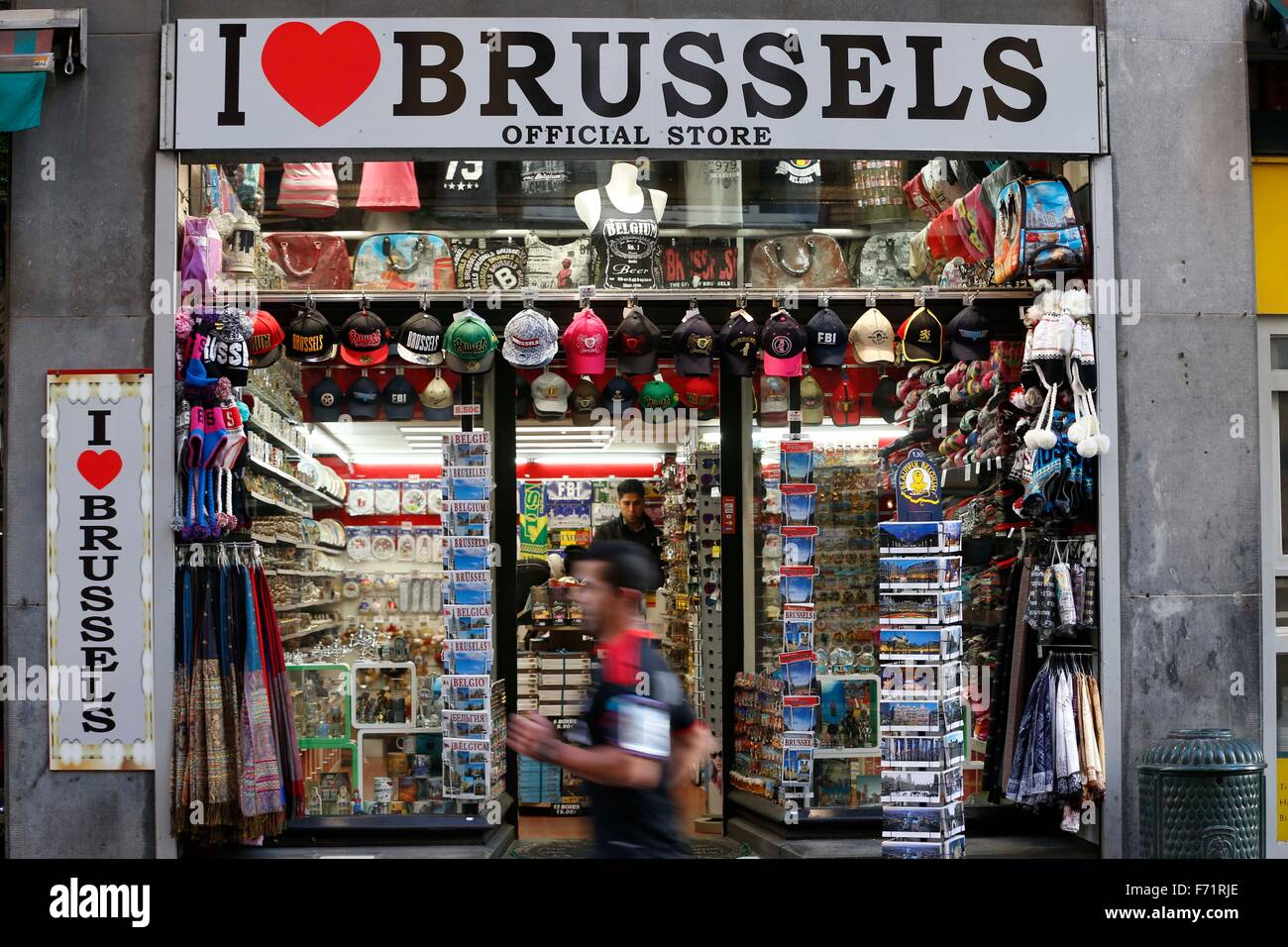 Brussels, Belgium. 23rd Nov, 2015. A man runs past a souvenir shop in