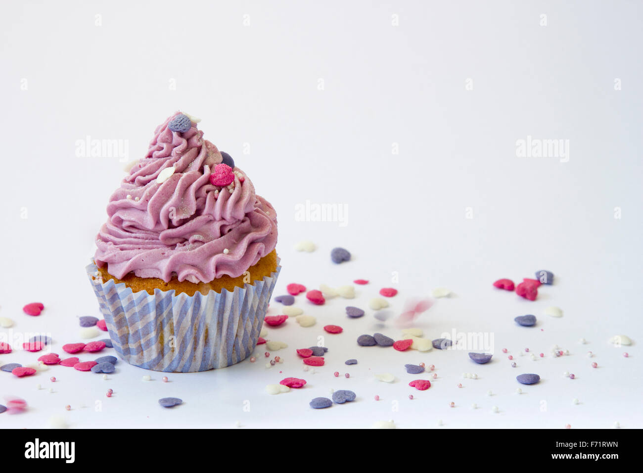 Single purple cupcake with assorted sprinkles Stock Photo