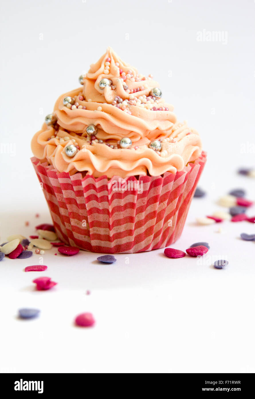 Single pink cupcake with assorted sprinkles Stock Photo