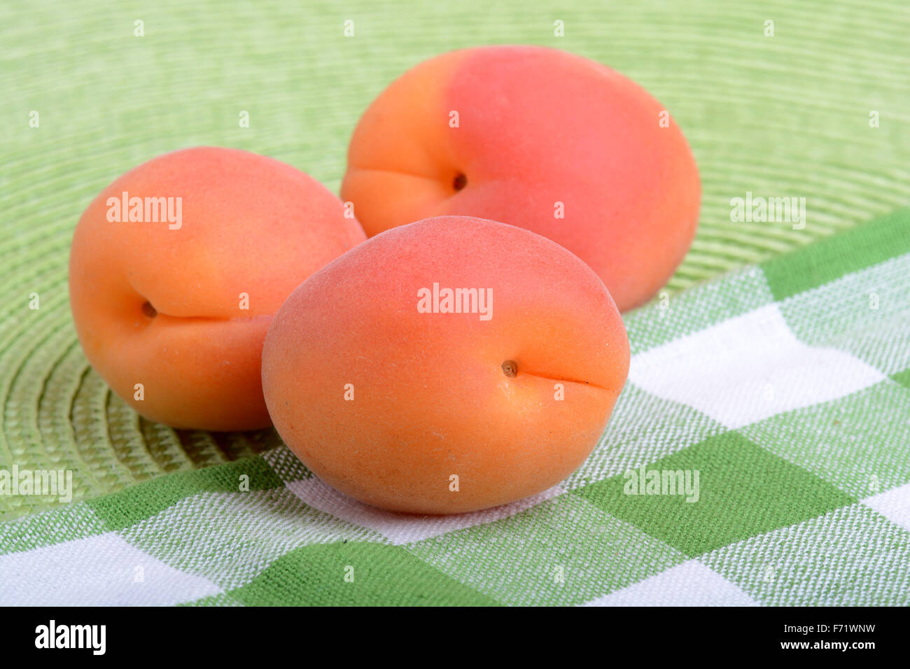 Full peaches close up on green material background Stock Photo