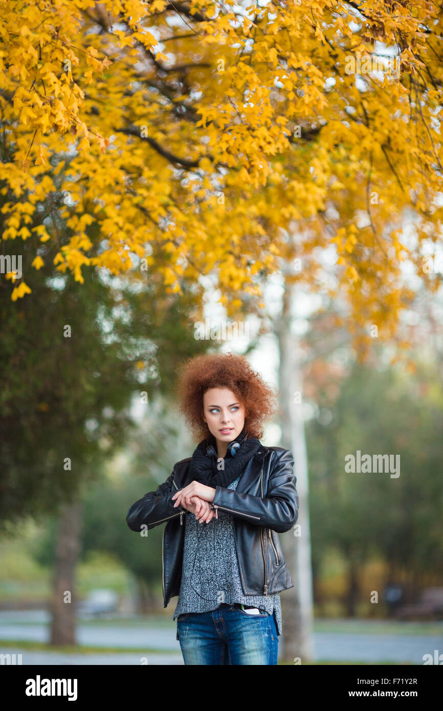 Portrait of a young woman with curly hair waiting for somebody outdoors Stock Photo