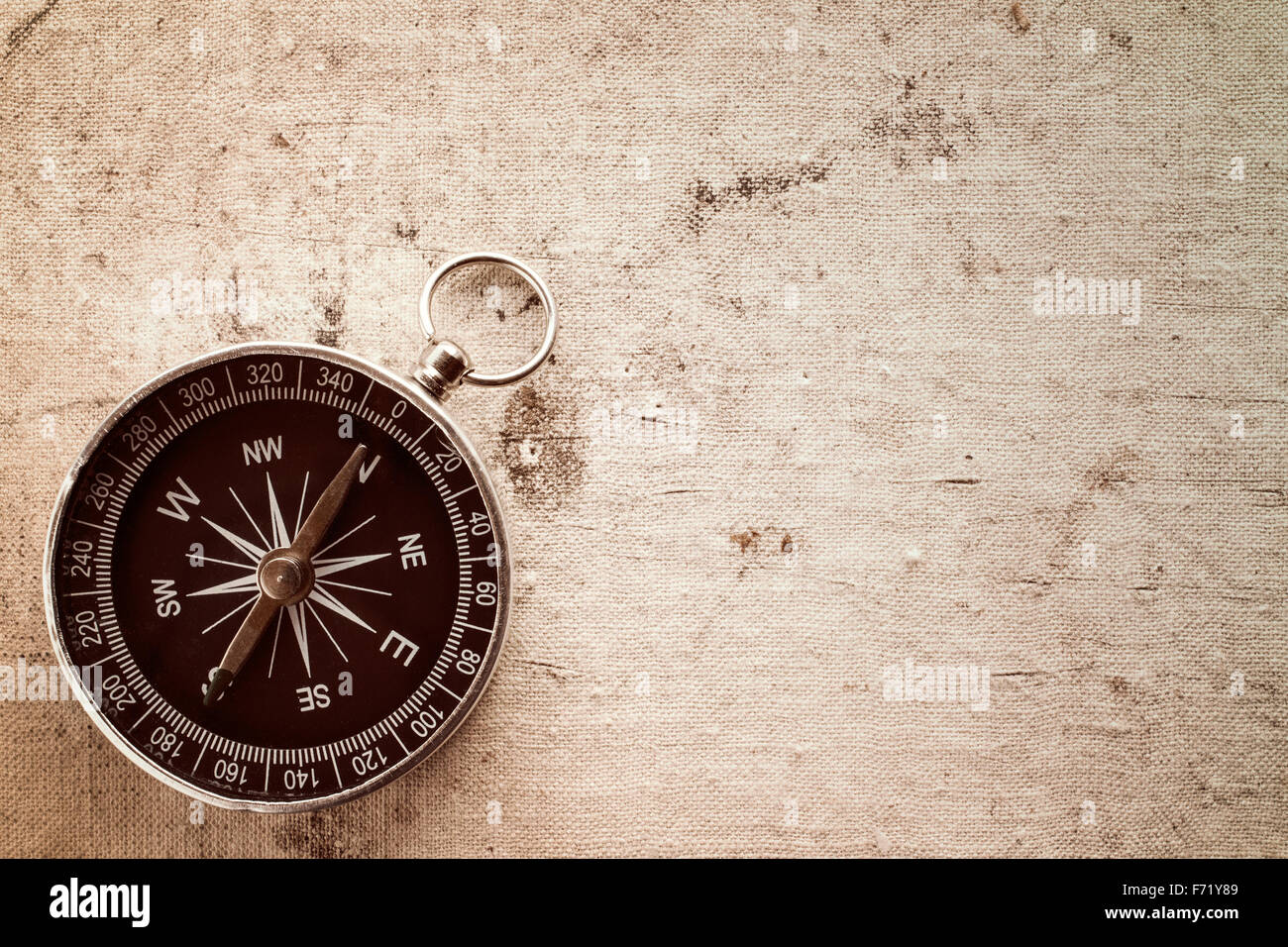 Compass on old canvas texture with copy-space Stock Photo - Alamy