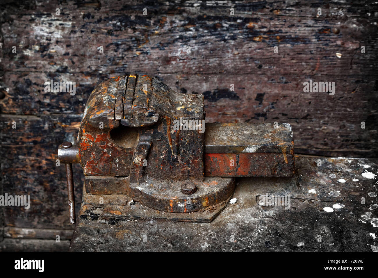An old weathered and rusted vice on a workbench. Stock Photo