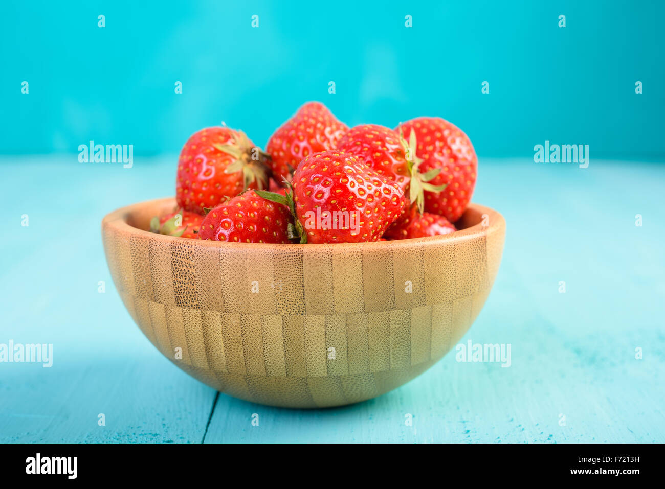 Strawberry Wood Bowl On Blue Boards Background Stock Photo - Alamy