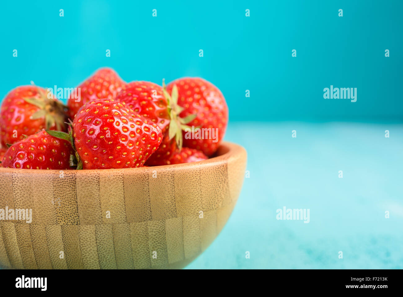 Strawberry Wood Bowl On Blue Boards Background Stock Photo - Alamy
