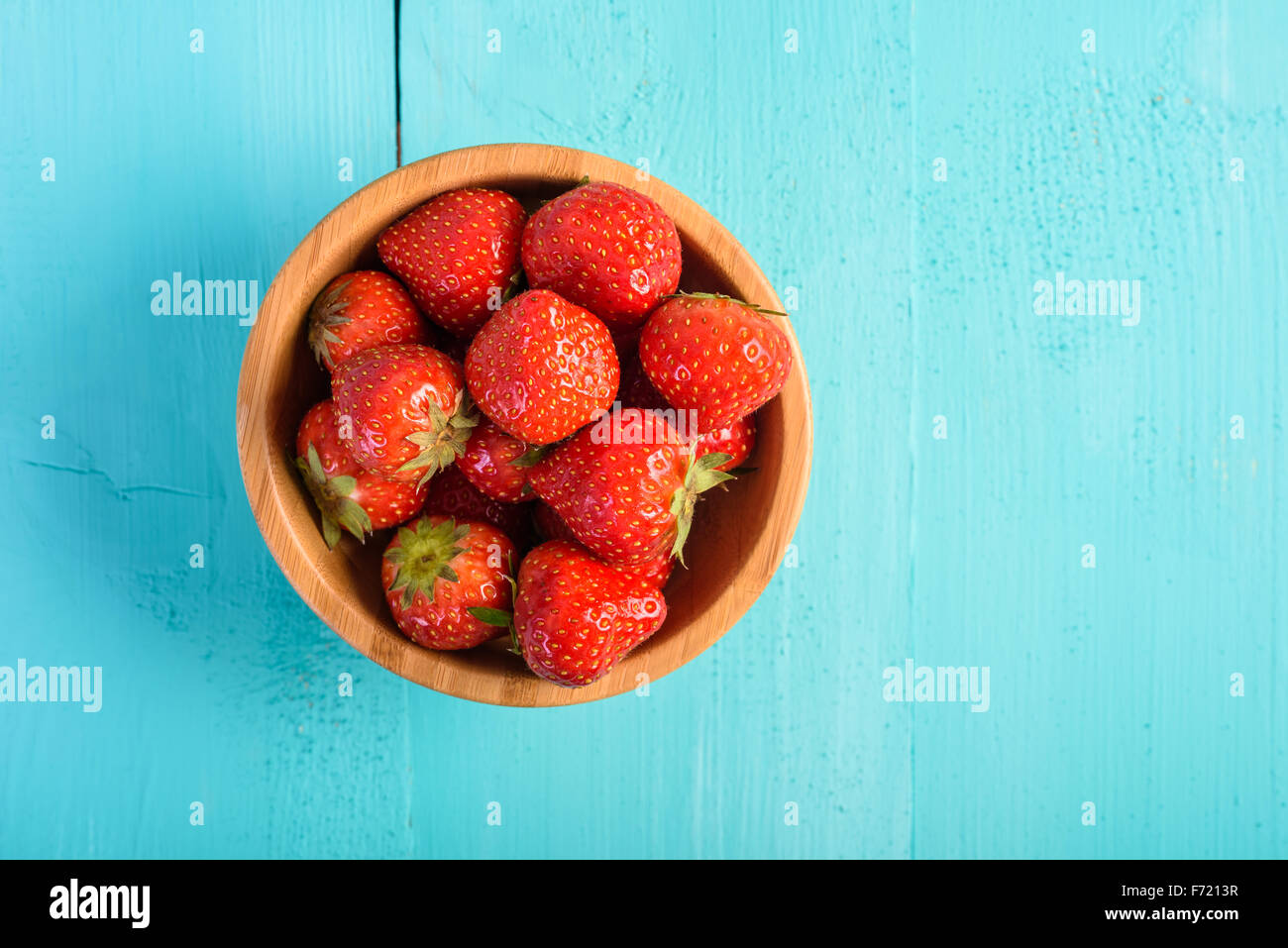 Strawberry Wood Bowl On Blue Boards Background Stock Photo - Alamy