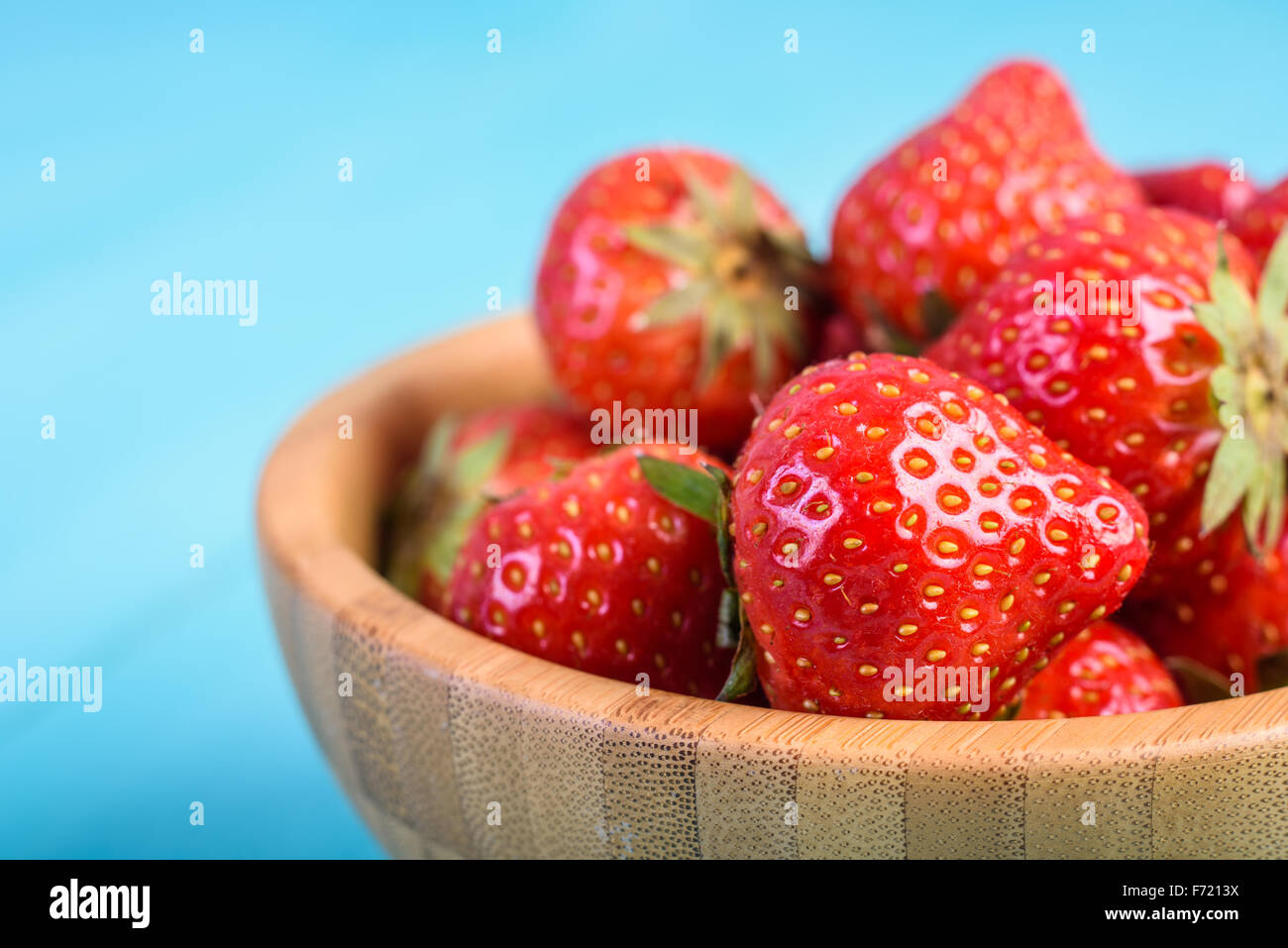 Strawberry Wood Bowl On Blue Boards Background Stock Photo - Alamy