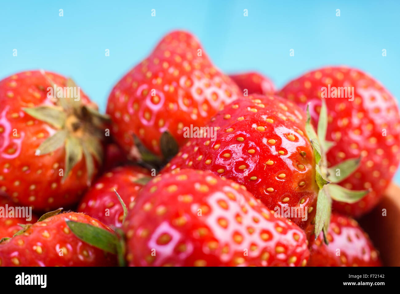Strawberry Wood Bowl On Blue Boards Background Stock Photo - Alamy