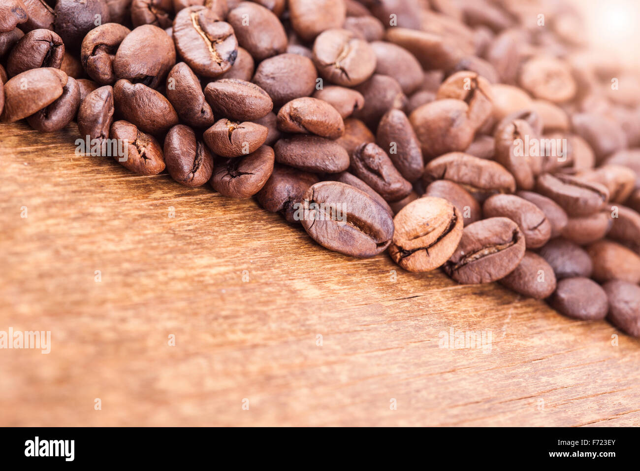 coffee grains on wooden background. light effect in the corner Stock Photo