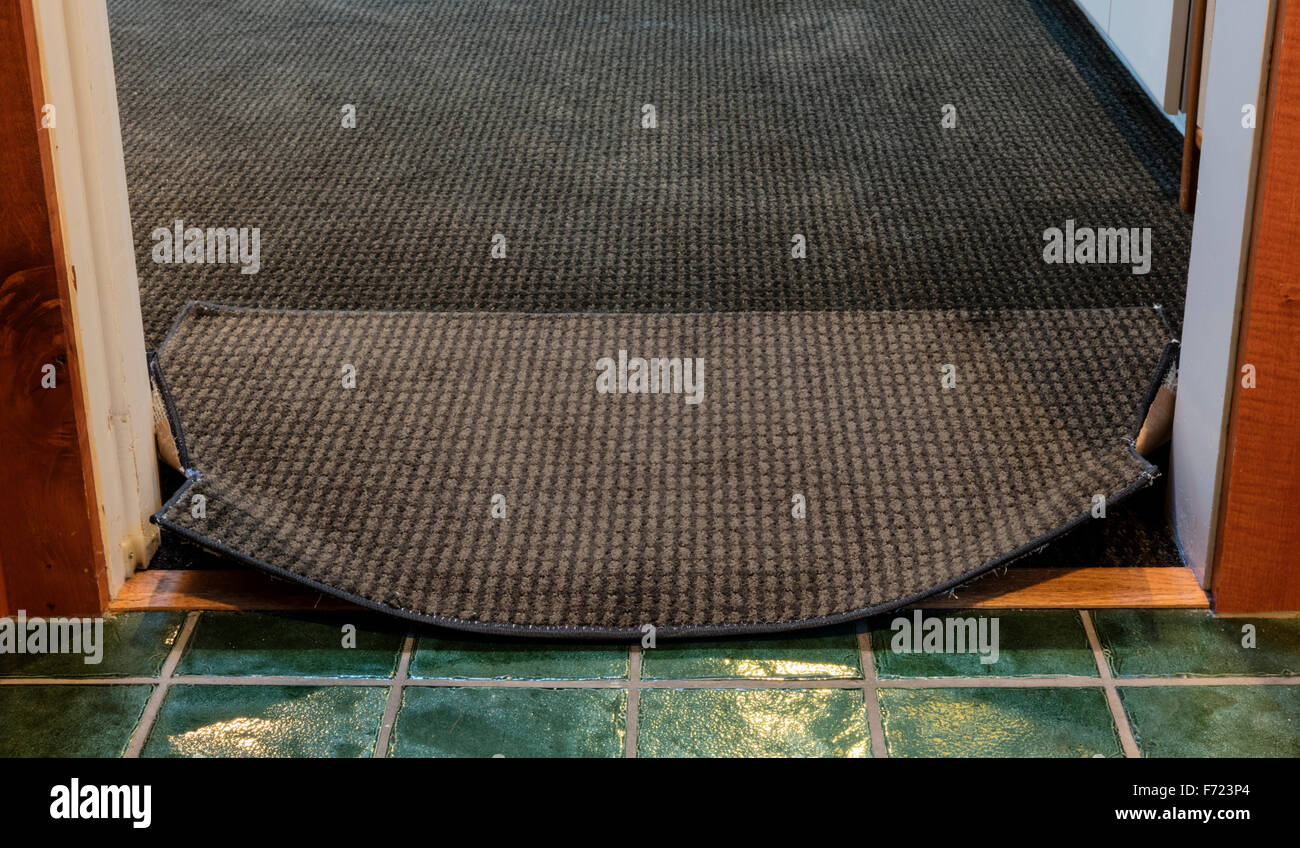 Turned up corners and edge of rug caught on door frame pose tripping ...