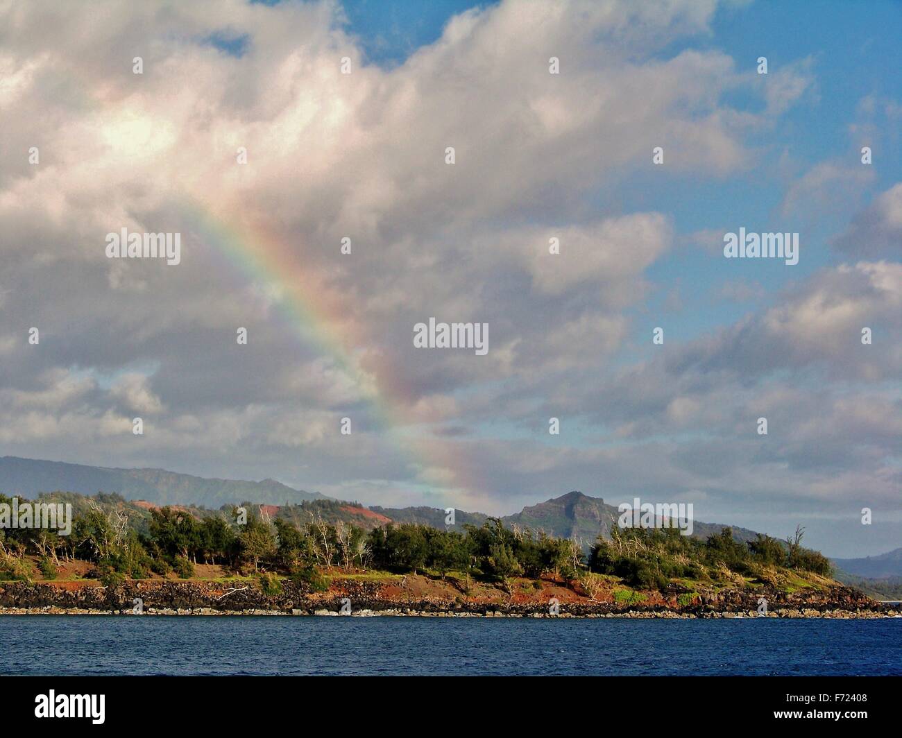 Hawaiian rainbow over mountains and sea Stock Photo