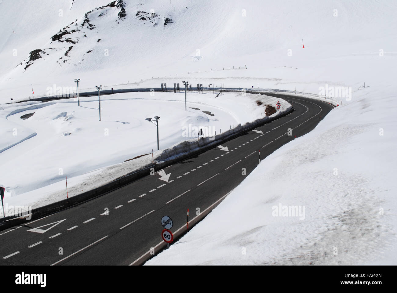 A mountain road bending in the snowy Pyrenees in Andorra. Stock Photo