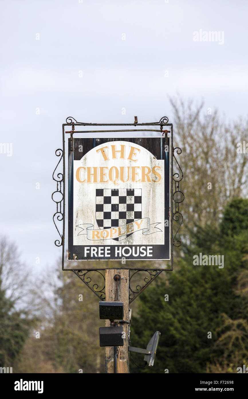 Dirty, neglected pub sign for The Chequers public house, a failed, closed down pub in Ropley, Hampshire, UK Stock Photo