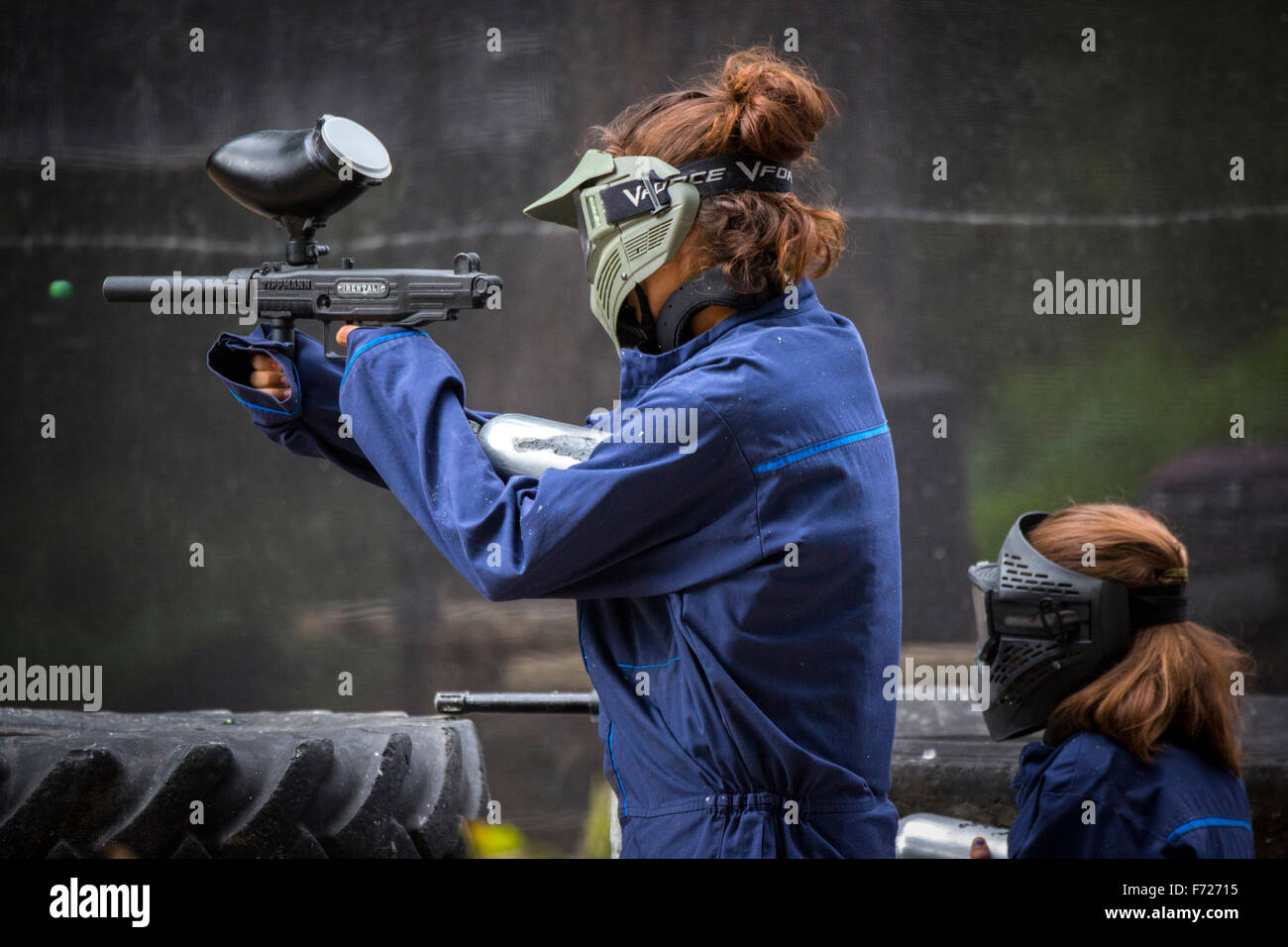 Paintball player girls at work. Jeunes joueuses de paintball en action. Stock Photo