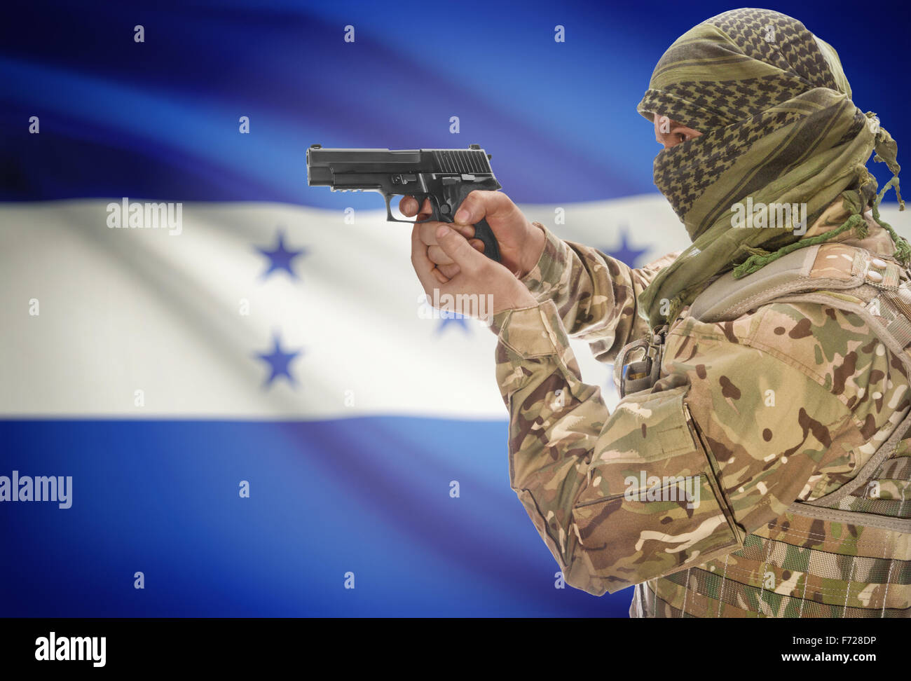 Male in muslim keffiyeh with gun in hand and national flag on background series - Honduras Stock Photo
