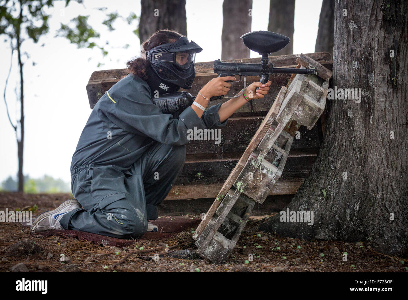 A paintball player girl at work. Jeune fille joueuse de paintball en action. Stock Photo