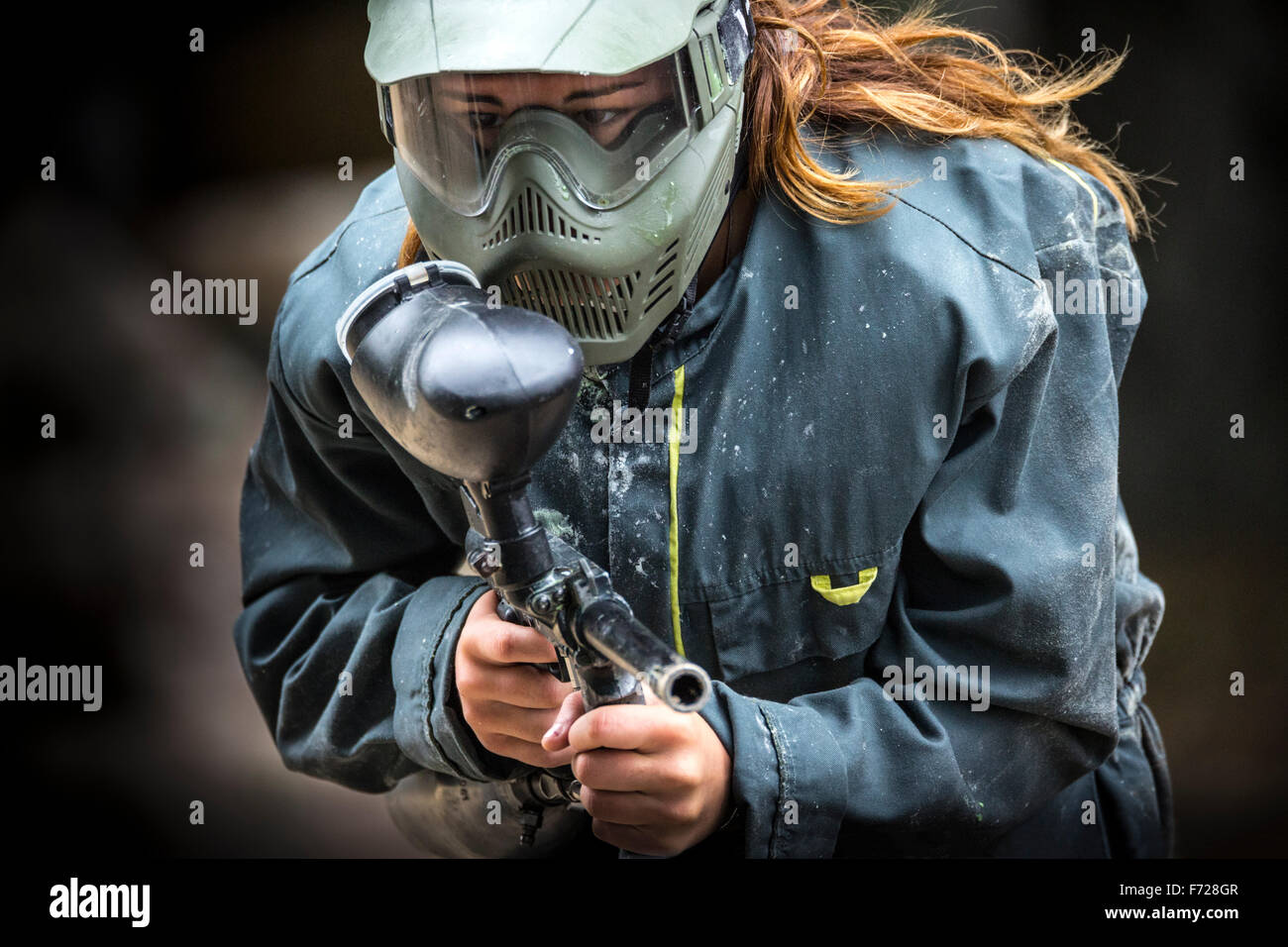 A paintball player girl at work. Jeune fille joueuse de paintball en action. Stock Photo