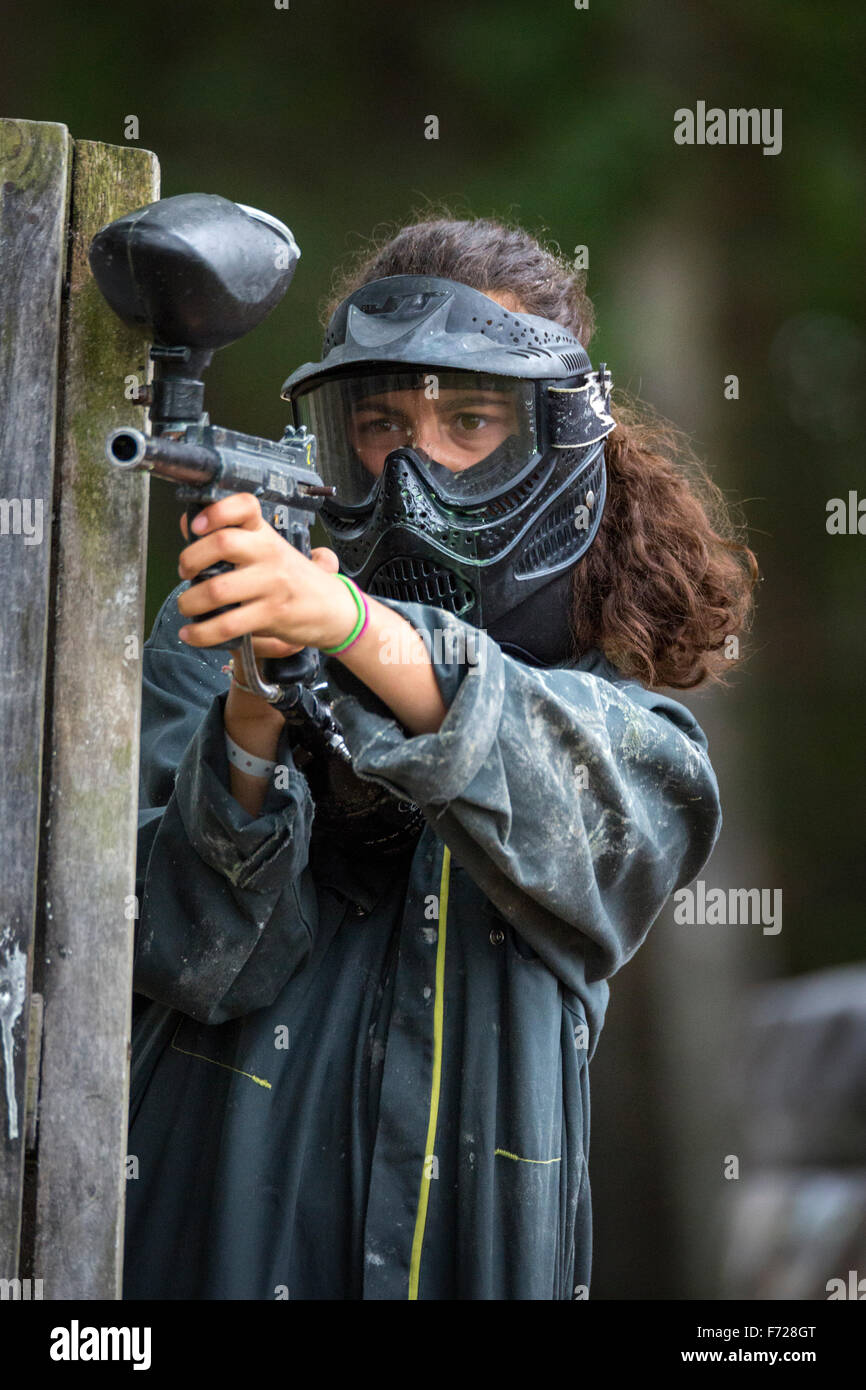 Portrait of a paintball player girl at work. Portrait d'une jeune joueuse de paintball en action. Stock Photo