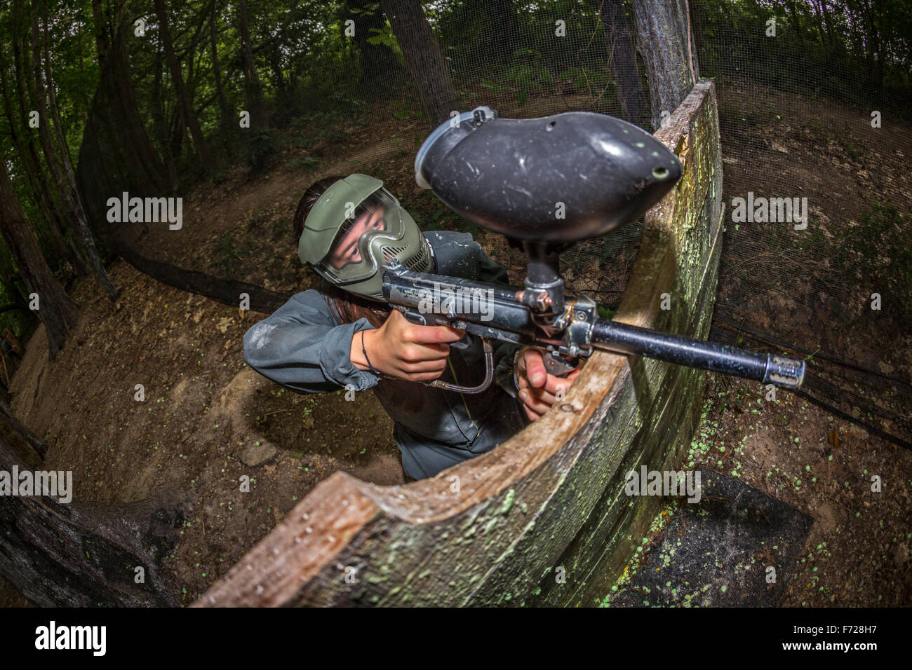 A paintball player girl at work. Jeune fille joueuse de paintball en action. Stock Photo