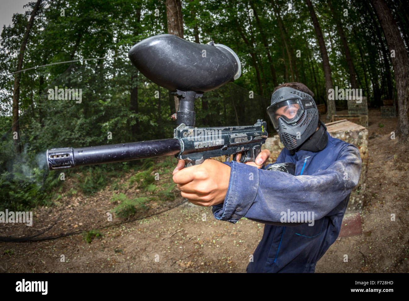 A paintball player teenager at work. Adolescent joueur de paintball en action. Stock Photo