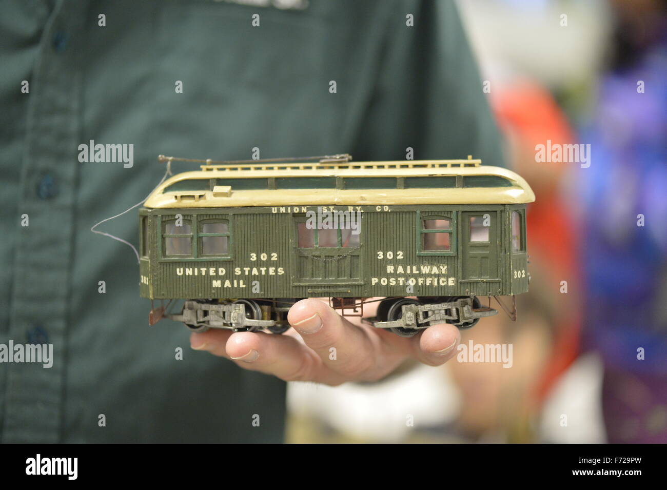 Bethpage, New York, USA. 22nd November 2015. FRANK KOBYLARZ, a co-founder of the Long Island Traction Society, holds a green Scratch Built 202 United States Mail Railway Post Office Trolley car. Kobylarz explained his O-Gauge trolley was not built from a kit but from basic materials such as wood, and that the original trolley it is modeled on operated from 1922-1937 in NY, NJ, New Haven, Bronx, Brooklyn. The trolley trains layout is one of several operating layouts at the 6th Annual Nassau County Model Train Show, held at the Bethpage Senior Community Center. Stock Photo