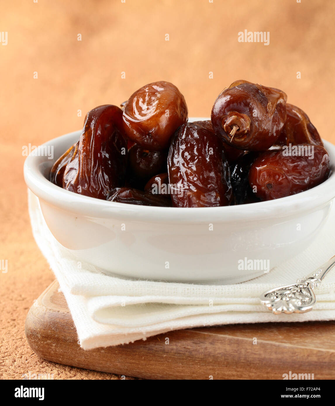 sweet dried dates in bowl on a wooden table Stock Photo - Alamy