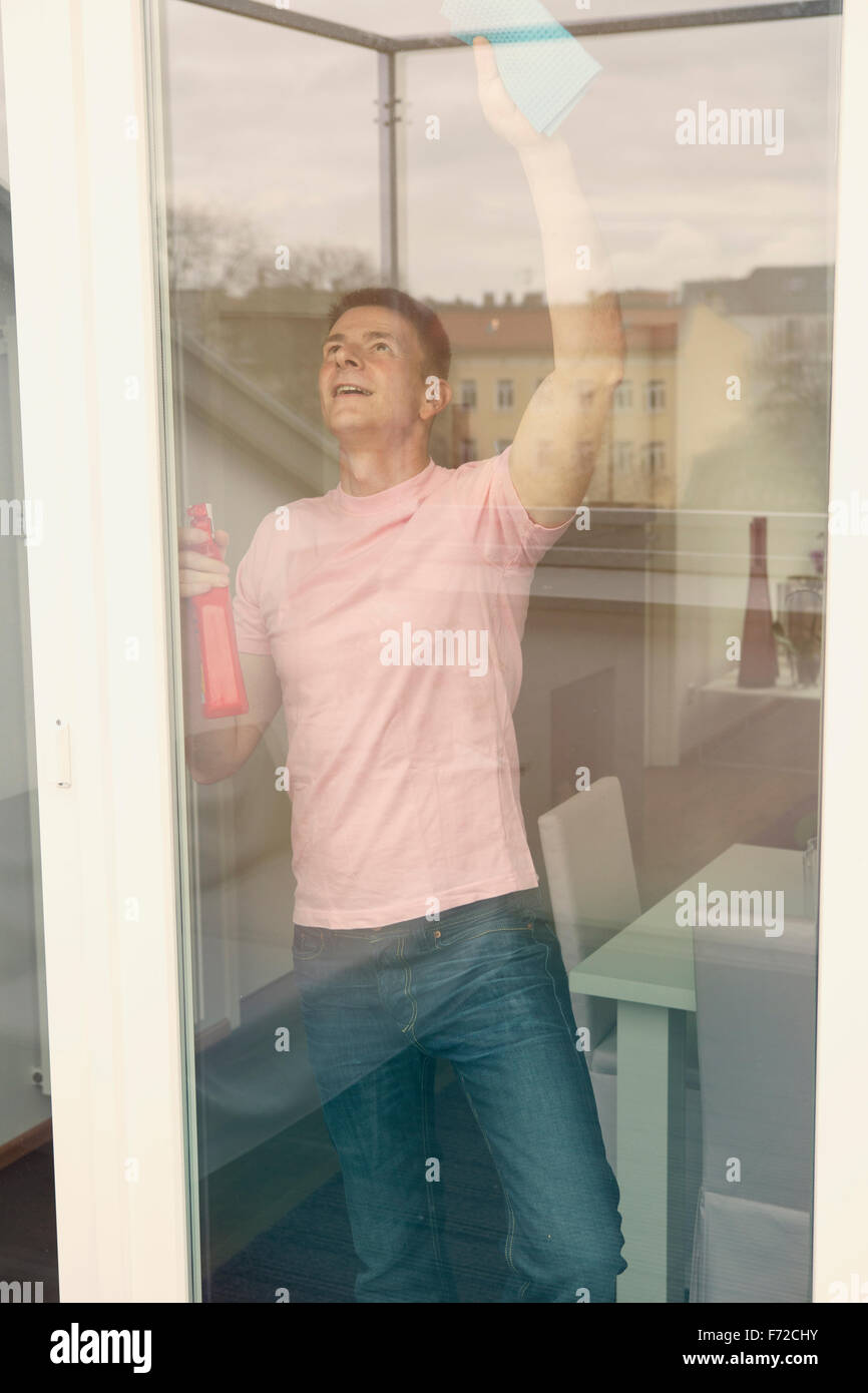 handsome man cleaning a big window Stock Photo