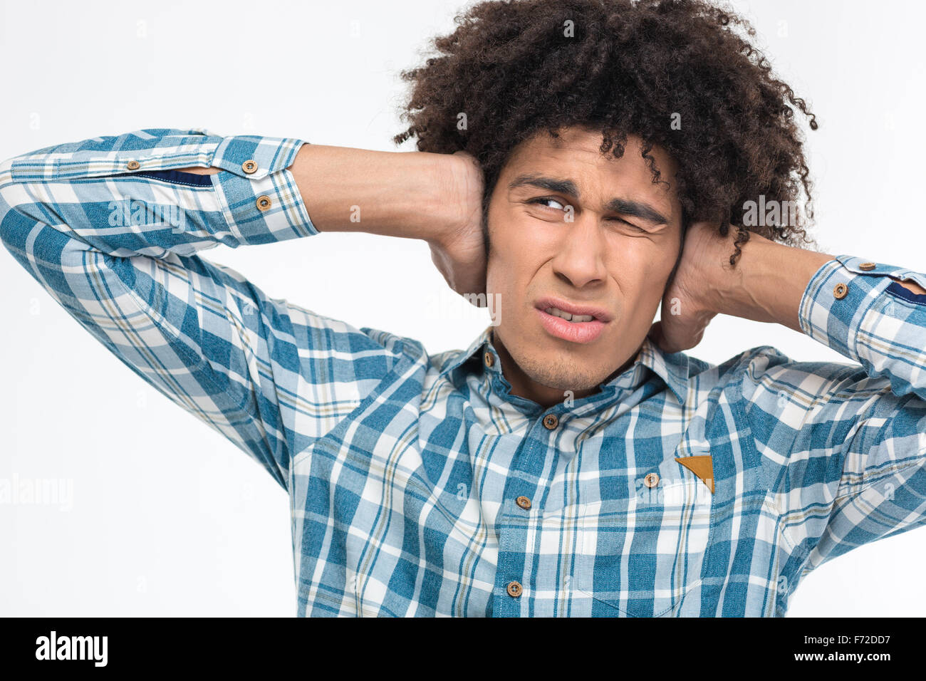 Portrait of depressed afro american man with curly hair covering his ears isolated on a white background Stock Photo