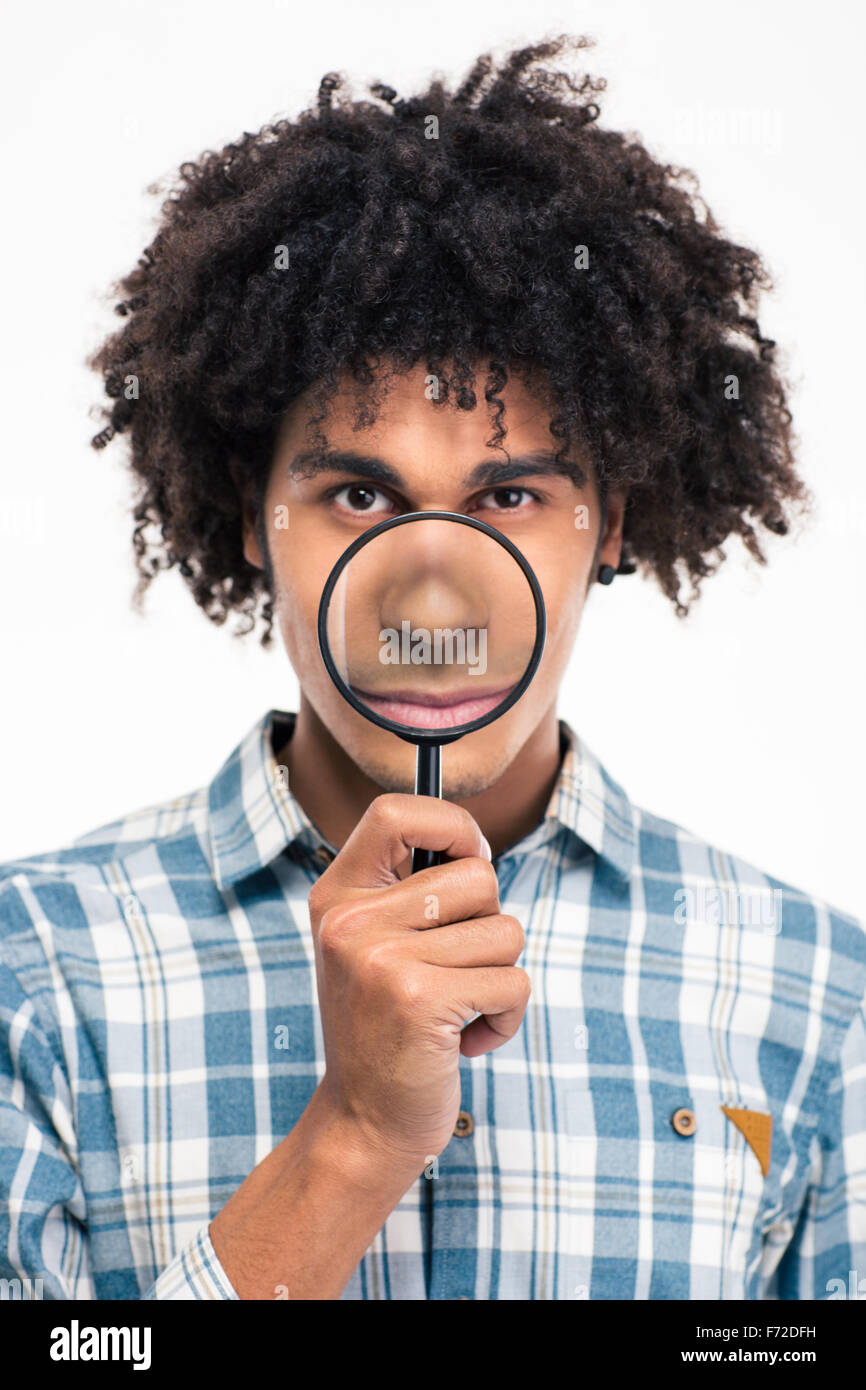 Portrait of a young afro american man holding magnifying glass isolated on a white background Stock Photo
